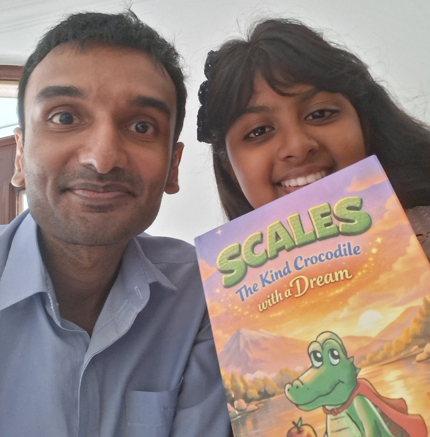 A printed copy of Scales, the Kind Crocodile with a Dream, held in someone’s hands.